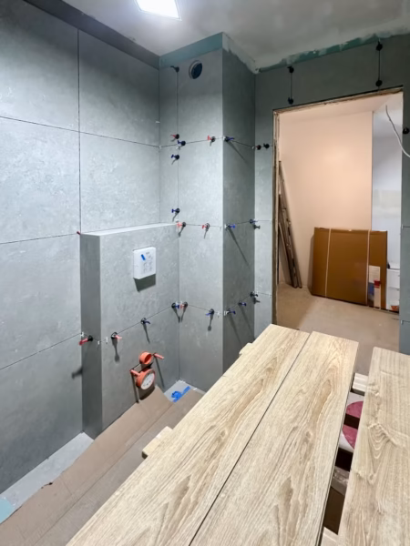 Etap wykańczania łazienki – montaż płytek ceramicznych na przygotowanym podłożu z hydroizolacją
