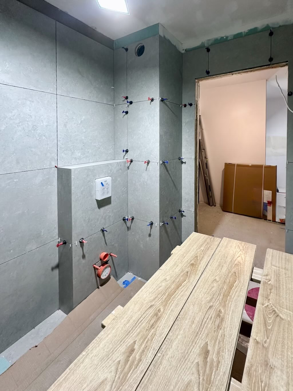 Etap wykańczania łazienki – montaż płytek ceramicznych na przygotowanym podłożu z hydroizolacją